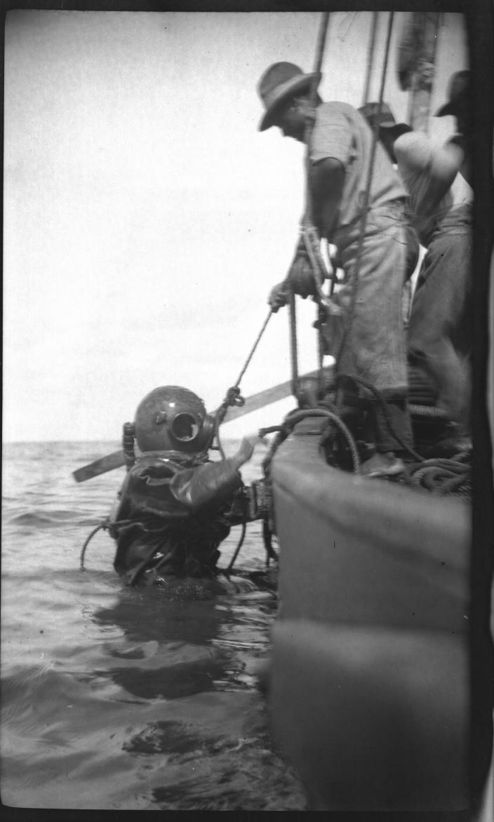 Image of a person hauling a diver out of the ocean